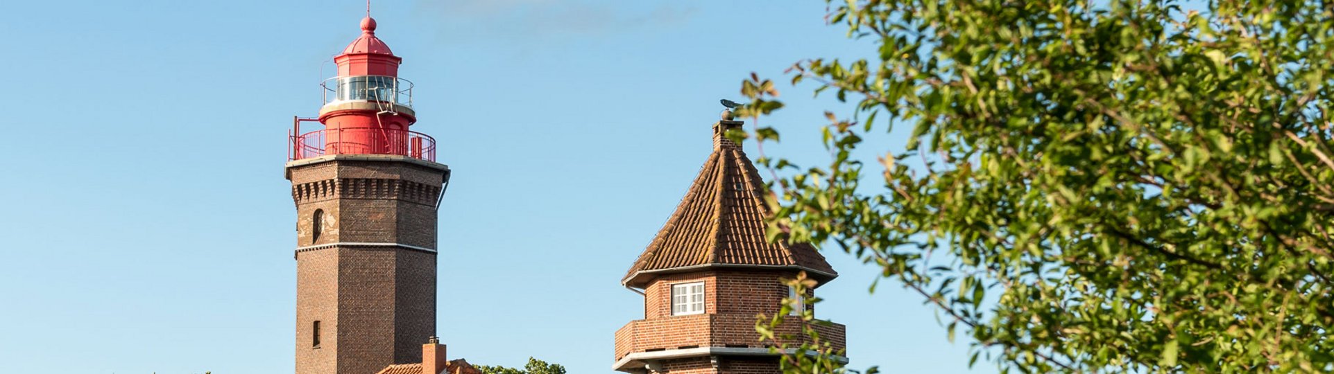 Ein Leuchtturm aus Backstein, daneben ein zweiter, kleinerer Trum