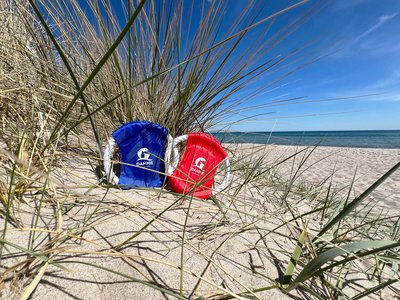 Zwei Wurfscheiben für Hunde liegen am Strand in einer Düne