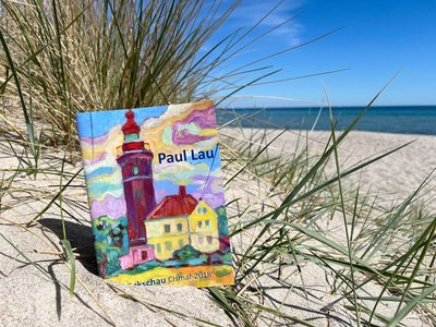 Ein Buch liegt am Strand in einer Düne