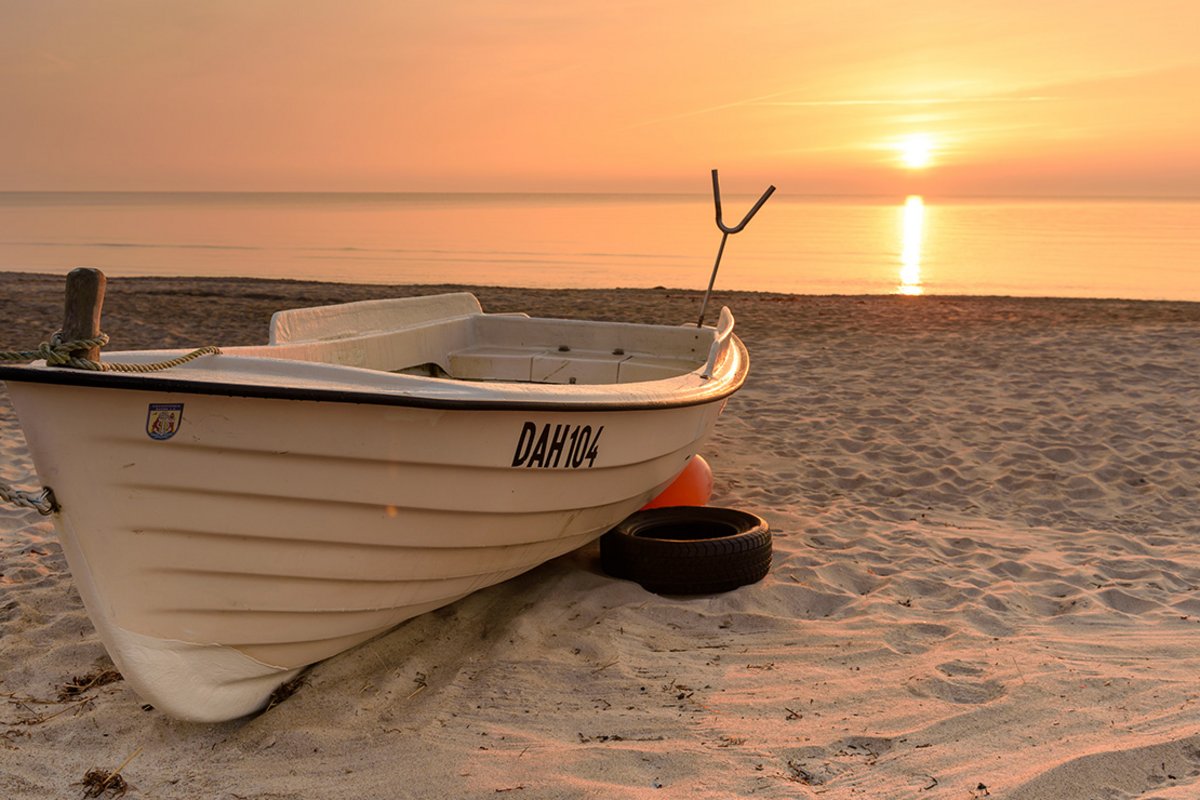 ein Boot am Strand bei Sonnenaufgang