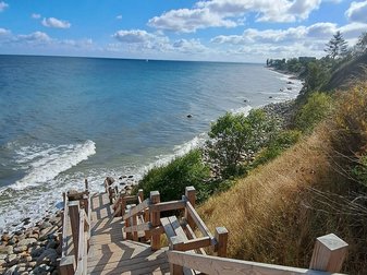 Eine hölzerne Treppe führt die Steilküste hinab ans Meer