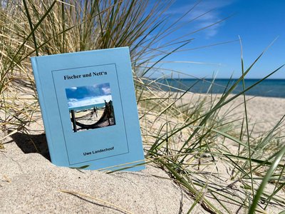 Ein Buch liegt am Strand in einer Düne