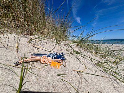 Schlüsselbänder liegen am Strand in einer Düne