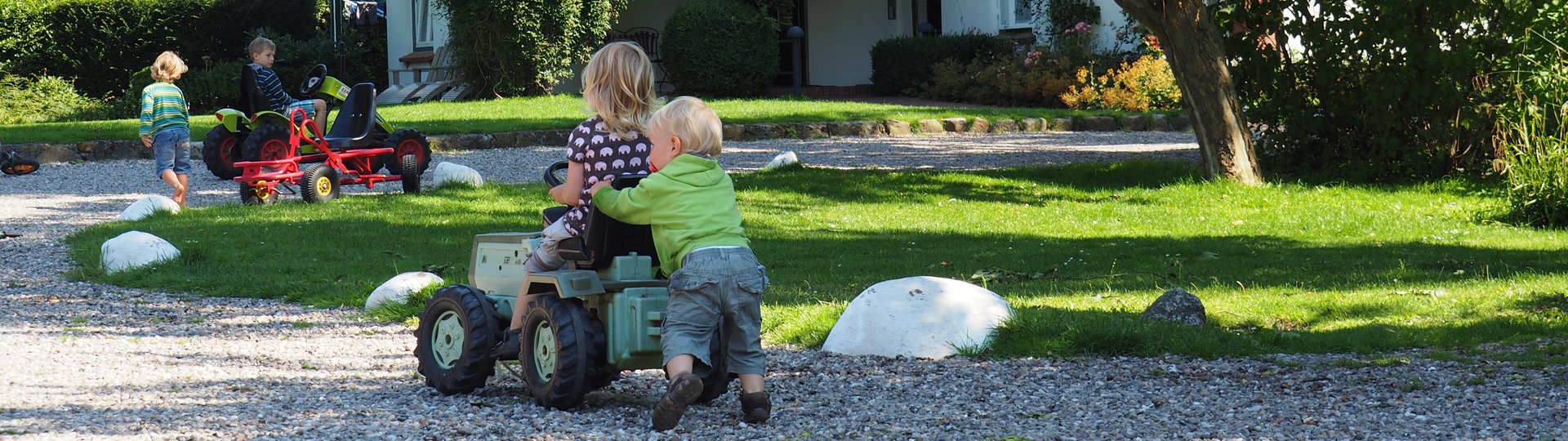 Mehrere Kinder spielen mit einem Spielzeugtrecker