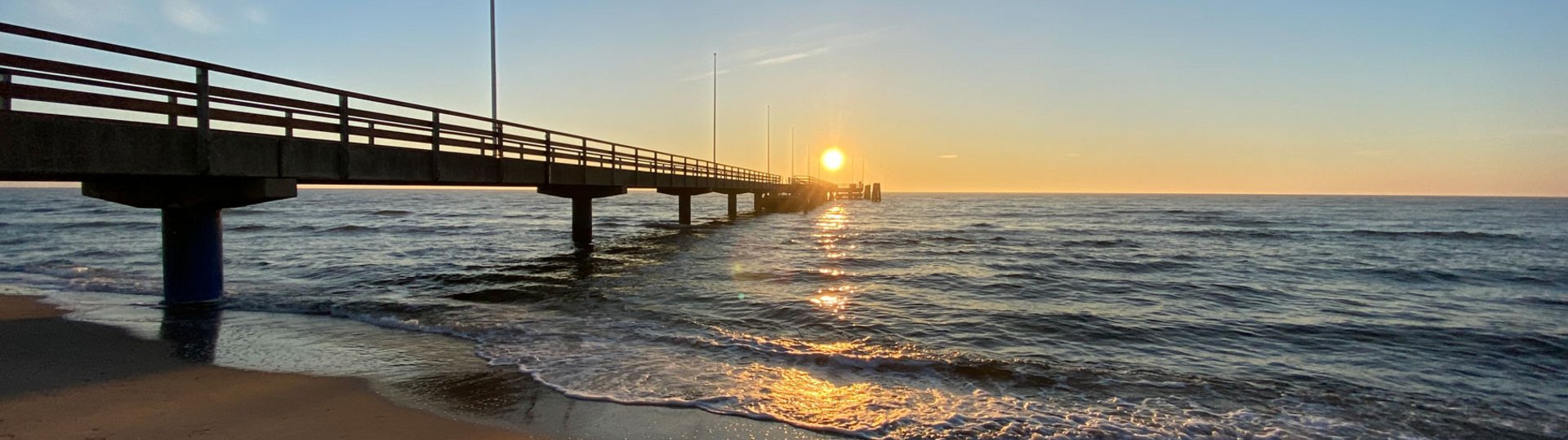 Eine hölzerne Seebrücke bei Sonnenuntergang